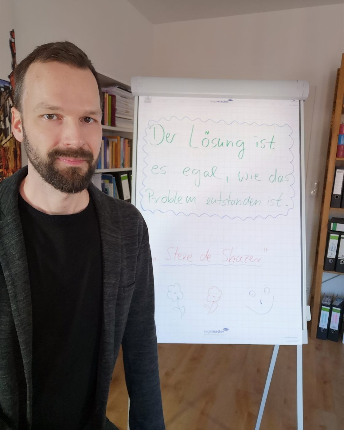 Nils Waitkus vor einem Flipchart mit einem Zitat von Steve de Shazer